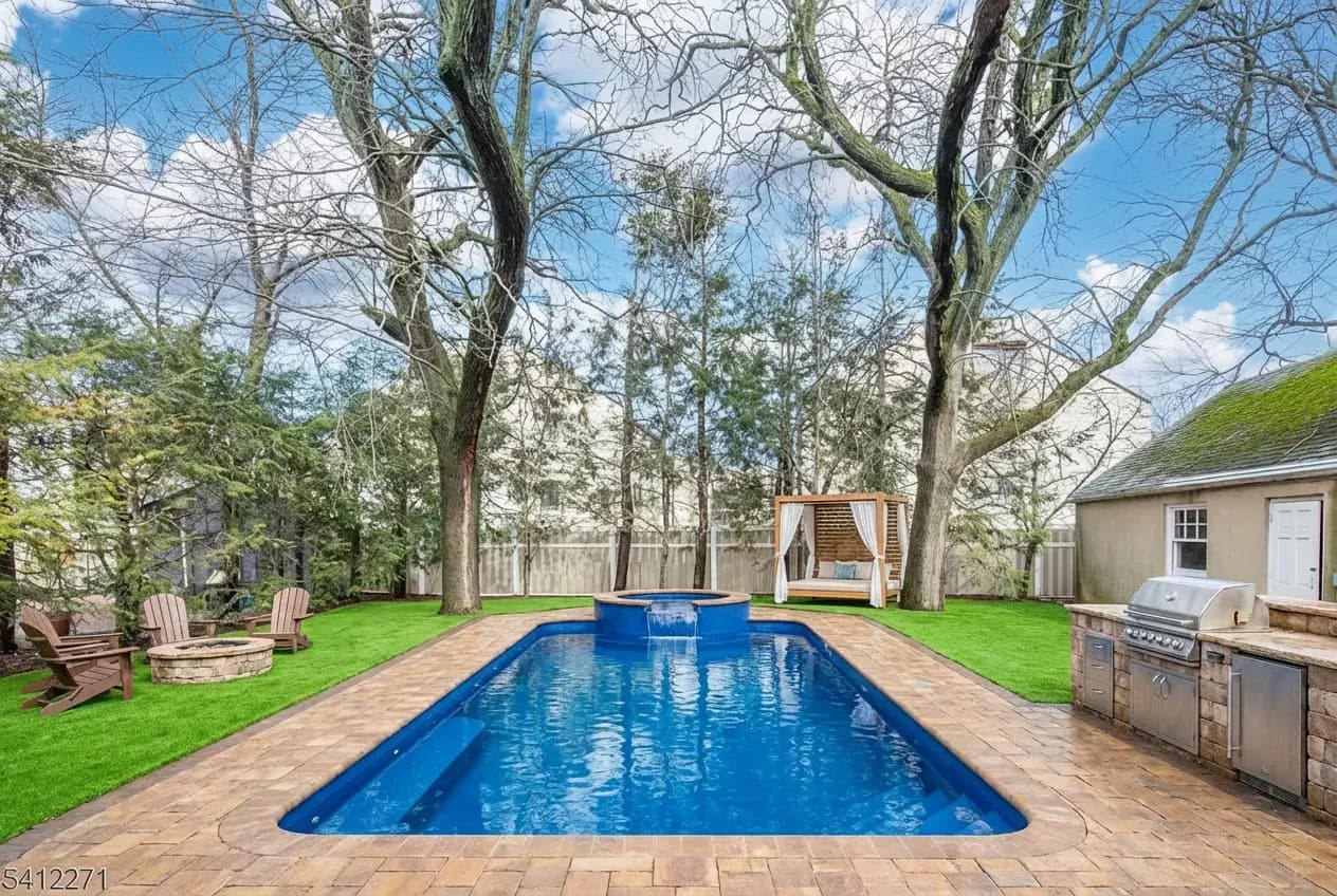 Design 2 — fiberglass rectangular pool, paver deck, raised spa, turf, fire pit, cabana, and outdoor kitchen designed by Seasonal World