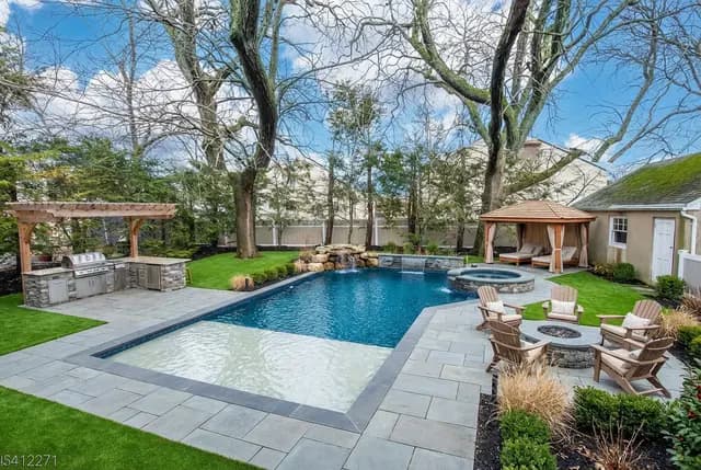 Design 1 — gunite L-shape pool, bluestone patio, fire pit, pergola, cabana, and turf designed by Seasonal World